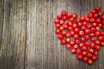 heart of red berries on a wood background 