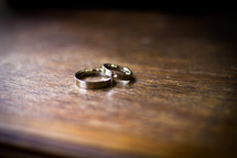 Wedding bands on a wooden table.