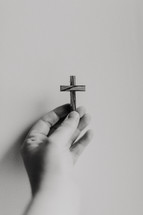 hand holding up a wooden cross