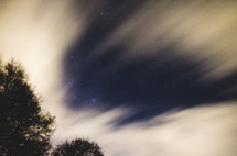 hazy streaks of clouds in the sky at night 