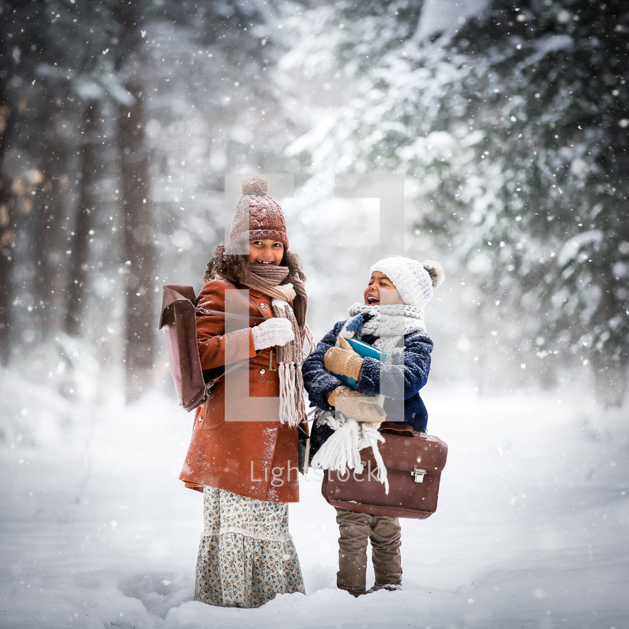 happy children standing in falling snow 