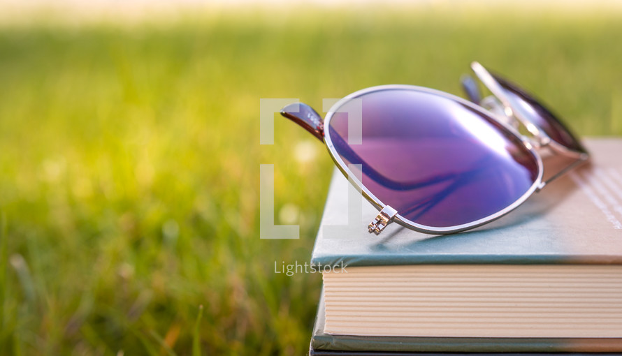 sunglasses on a stack of books 
