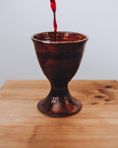pouring wine into a communion wine chalice 