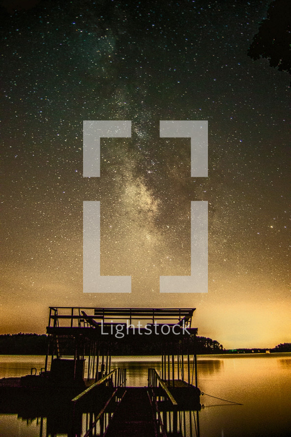 stars in a night sky over a dock at night 