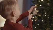 a child decorating a Christmas tree 
