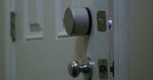 Smart home door lock automatically locks itself once door is closed - close up on door locking 