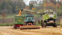 Tractors plowing field of crops.