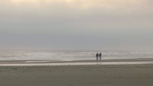 a couple walking holding hands on a beach 
