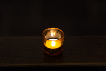 A glowing votive candle.
