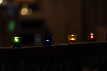 Candles glowing in colorful votives.