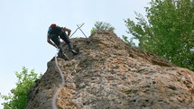 a woman lowering a rope rock climbing 
