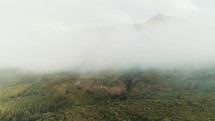 drone over thick clouds on a mountainside 