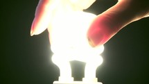 woman screwing in a lightbulb 