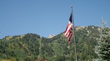American flag blowing in the breeze and mountain 