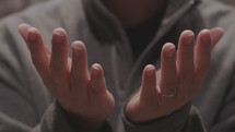 a man praying with uplifted hands 