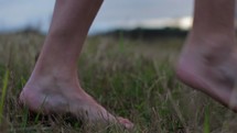 Feet  walking through a field.