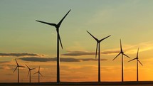 wind turbines spinning at sunset