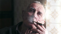 elderly man smoking a cigar 