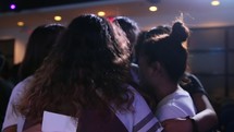 small groups hugging and praying at a youth conference 