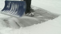 Shoveling snow off the sidewalk.