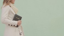 teen girl walking with a Bible 