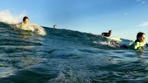 children riding boogie board on waves 