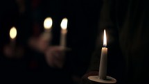 Rack focus of a candlelight Christmas service