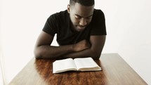 man reading a Bible at multiple angles 