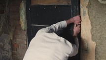 a man trying to pry a door open 