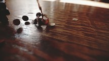 Coins falling on a wood floor and an open Bible.