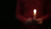 A man holding a candle swaying back and forth