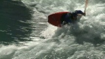 Person in canoe paddling on roaring rapids.