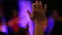 Hand raised in praise at a worship concert.