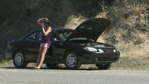broken down vehicle and a young woman on a cellphone