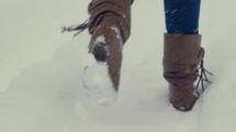 woman's boots walking in the snow 