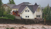 Flood waters rushing through a devastated community.
