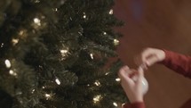 a child decorating a Christmas tree 