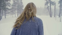 woman walking outdoors during a snowfall 