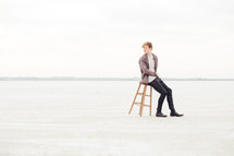 a man sitting on a stool in the great salt plains of Oklahoma 
