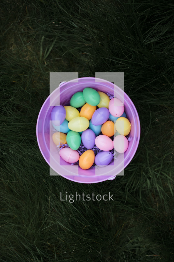 a bucket of Easter eggs in grass 