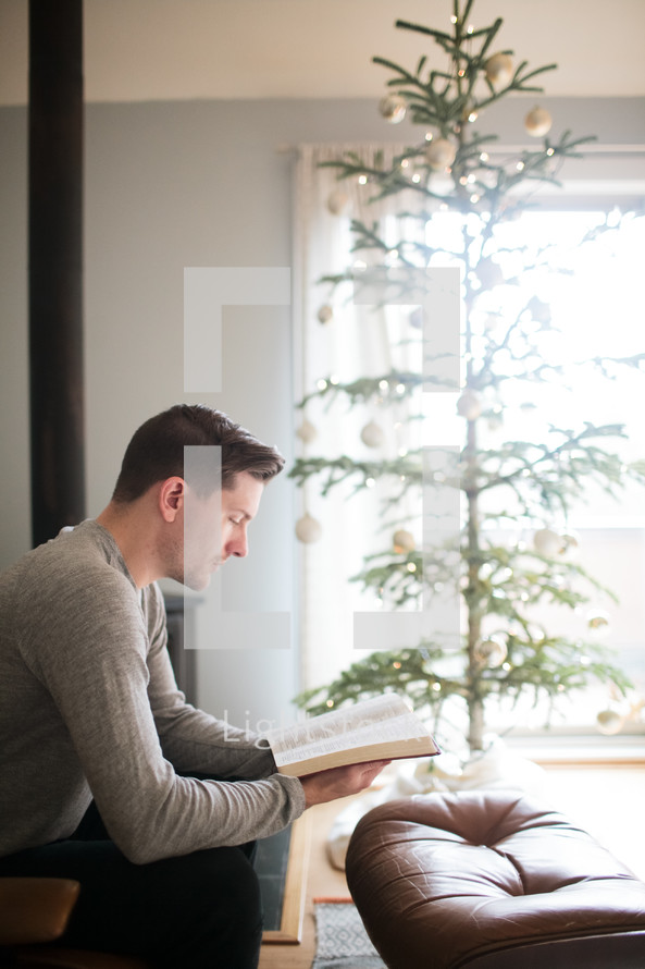 a man reading a Bible at Christmas time 