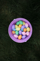 a bucket of Easter eggs in grass 
