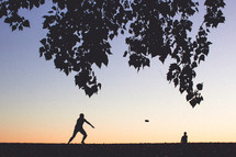 friends playing frisbee in a park 