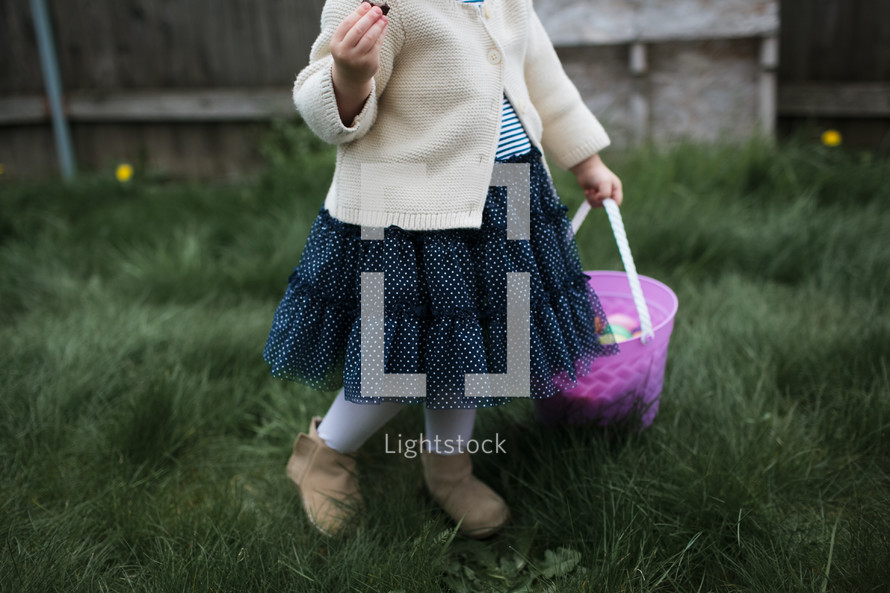 a toddler girl on an Easter egg hunt