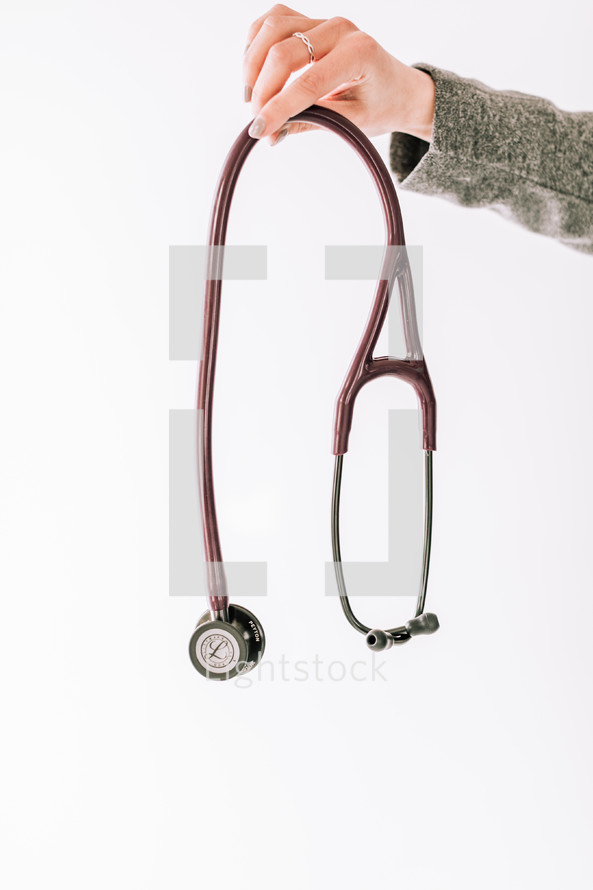a woman holding out a stethoscope 