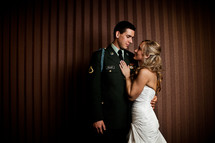 bride with her hands on the chest of her military groom