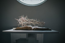 crown of thorns over the pages of a Bible on a stand 