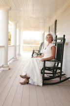 Woman sitting in rocking chair on a porch