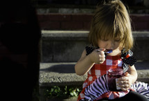 a toddler girl eating jam 