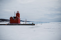 red lighthouse in snow and ice 